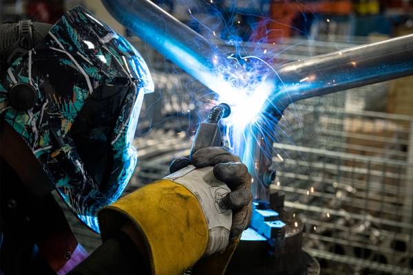 A metal worker welding pipes