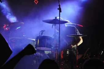 Drummer playing on a poorly lit stage