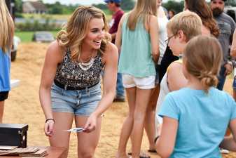 Woman smiling while talking to young kids