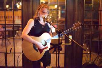 a young woman playing guitar and singing