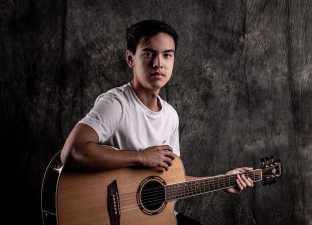 young man holding a guitar