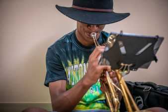 man playing the trumpet, his bucket hat covers his eyes