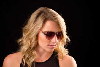 blond woman in sunglasses looking down with her eyes closed