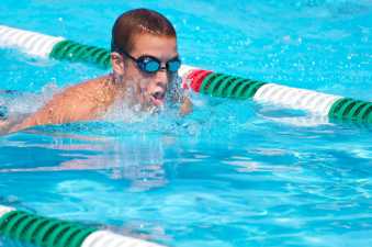 young man in goggles swimming in his lane