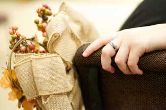 a hand with a wedding band and fall wedding decorations