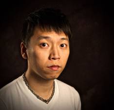 a dark haired man looking at the camera with a serious face