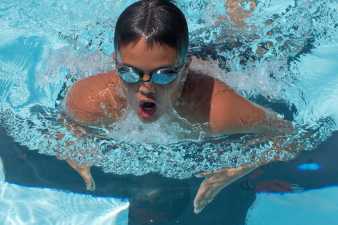 young man taking a breath during his swimming race