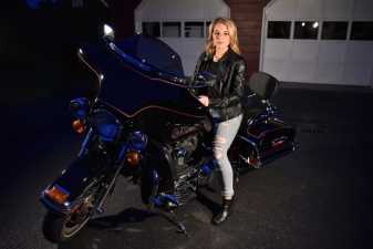 a young woman on a harley at night in her driveway