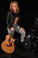 a young woman on a harley at night in her driveway, holding a guitar
