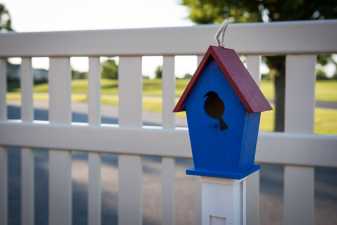 blue birdhouse sitting on a fence