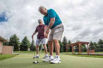 two older men practicing putting