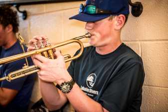 a male student practicing his trumpet