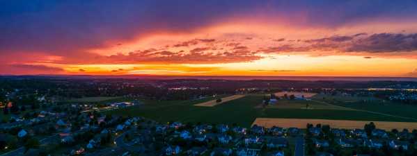 drone photo of a neighborhood and farmland at dusk