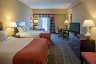 an empty hotel room with two beds