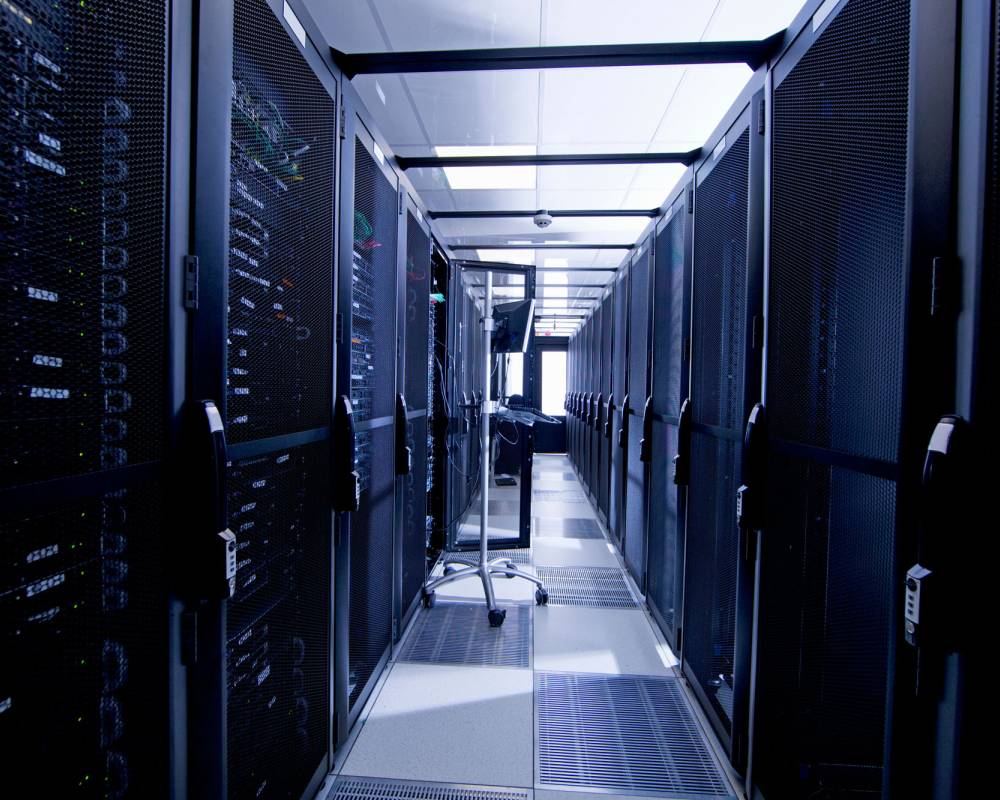 Server room aisle with blue lighting representing reliable hosting infrastructure