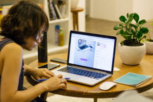 a woman holding a pen looking at a laptop