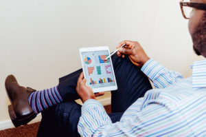 a man on an ipad looking at graphs