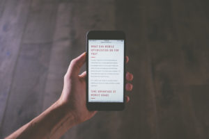 a hand holding a phone reading an article